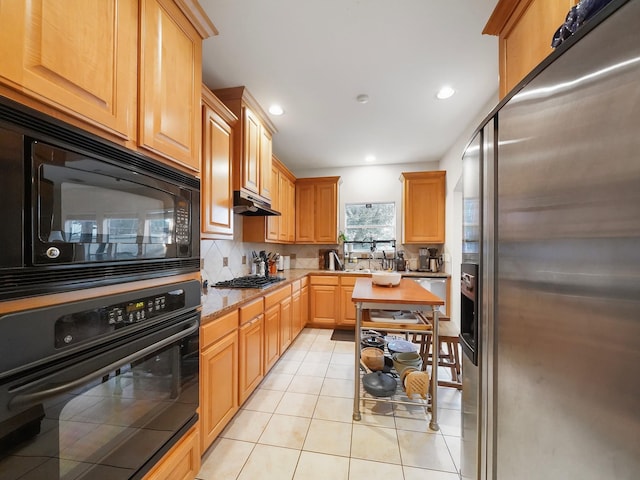 7106 Harmony Cv, Houston, TX 77036 - kitchen with black appliances, light tile patterned flooring, backsplash, recessed lighting, and under cabinet range hood