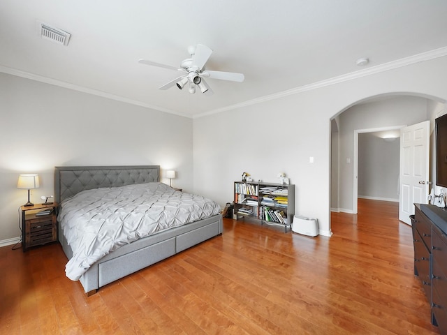 7106 Harmony Cv, Houston, TX 77036 - bedroom with arched walkways, wood finished floors, baseboards, ornamental molding, and ceiling fan