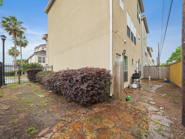 7106 Harmony Cv, Houston, TX 77036 - view of side of home featuring stucco siding, a fenced backyard, and a patio