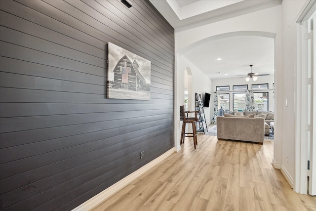 1810 Opal Field Ln, Richmond, TX 77469 - hall featuring arched walkways, wood walls, baseboards, light wood-type flooring, and recessed lighting