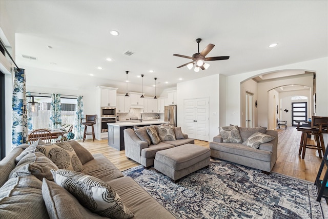 1810 Opal Field Ln, Richmond, TX 77469 - living room with healthy amount of natural light, arched walkways, light wood-style floors, and recessed lighting