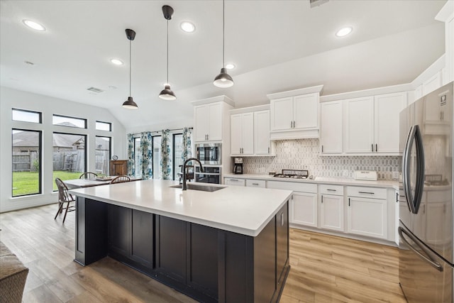 1810 Opal Field Ln, Richmond, TX 77469 - kitchen featuring appliances with stainless steel finishes, a sink, backsplash, light countertops, and vaulted ceiling