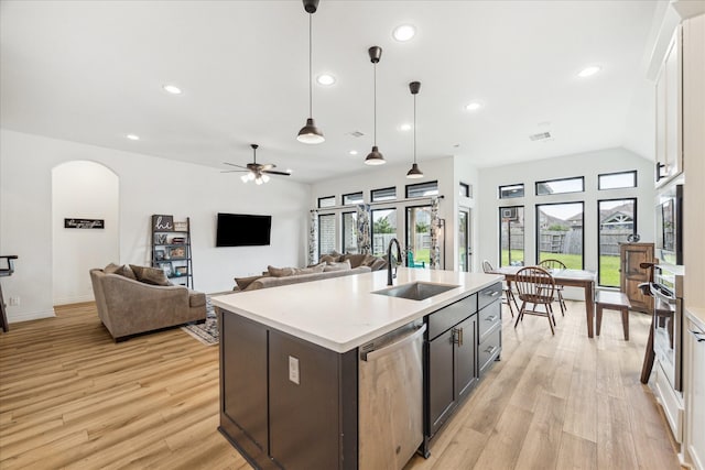 1810 Opal Field Ln, Richmond, TX 77469 - kitchen with stainless steel appliances, a sink, light wood-style floors, light countertops, and pendant lighting
