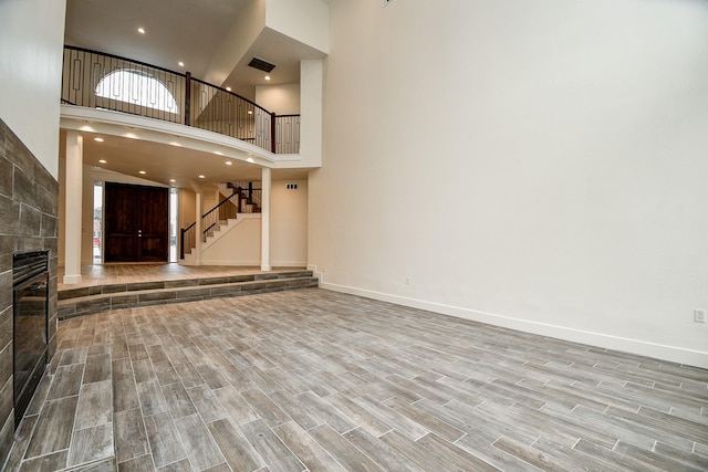 8115 Fondren Lake Dr, Houston, TX 77071 - unfurnished living room featuring a high ceiling, stairway, wood finished floors, baseboards, and recessed lighting