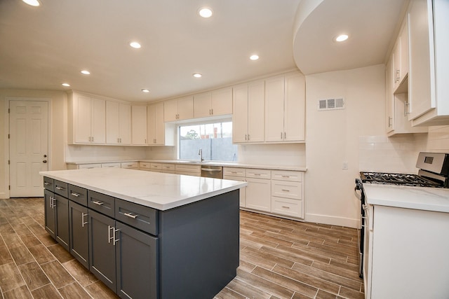 8115 Fondren Lake Dr, Houston, TX 77071 - kitchen featuring stainless steel appliances, white cabinets, gray cabinets, wood finished floors, and recessed lighting