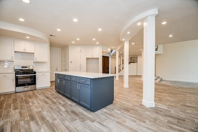 8115 Fondren Lake Dr, Houston, TX 77071 - kitchen with gas stove, white cabinetry, light wood finished floors, light countertops, and baseboards