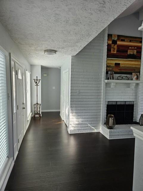 3311 Oyster Cove Dr, Missouri City, TX 77459 - entryway featuring dark wood-style floors, baseboards, a fireplace, and a textured ceiling