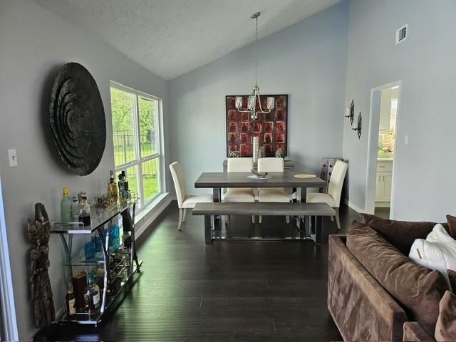 3311 Oyster Cove Dr, Missouri City, TX 77459 - dining area featuring lofted ceiling, dark wood finished floors, a chandelier, and baseboards