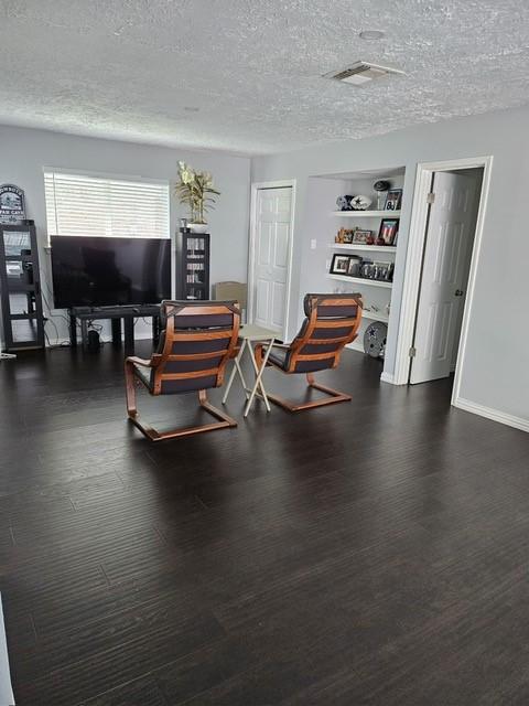 3311 Oyster Cove Dr, Missouri City, TX 77459 - living room featuring a textured ceiling, wood finished floors, baseboards, and built in features