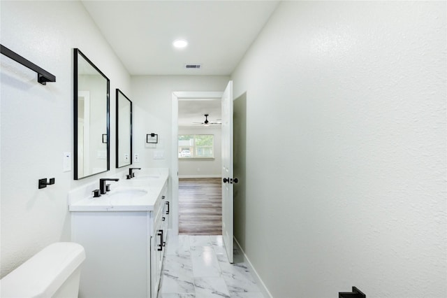 5978 Southmont St, Houston, TX 77033 - bathroom featuring marble look tile flooring, toilet, double vanity, ceiling fan, and baseboards