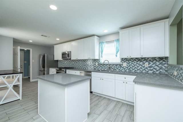 15923 Pine Mountain Dr, Houston, TX 77084 - kitchen with appliances with stainless steel finishes, a sink, white cabinets, tasteful backsplash, and recessed lighting