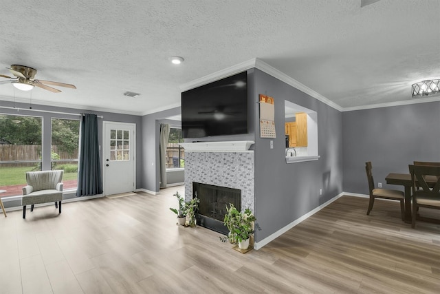 21406 Park Post Ln, Katy, TX 77450 - living room featuring ceiling fan, wood finished floors, crown molding, baseboards, and a textured ceiling