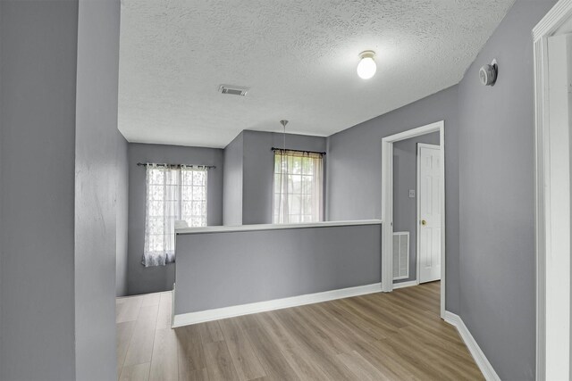 21406 Park Post Ln, Katy, TX 77450 - empty room with wood finished floors, baseboards, and a textured ceiling