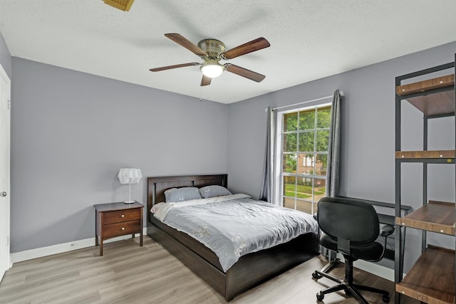 21406 Park Post Ln, Katy, TX 77450 - bedroom featuring light wood-style flooring, baseboards, a desk, a ceiling fan, and a textured ceiling