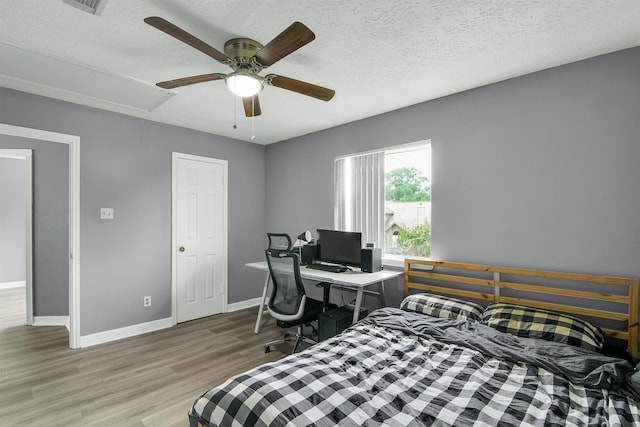 21406 Park Post Ln, Katy, TX 77450 - bedroom with attic access, wood finished floors, baseboards, a textured ceiling, and a ceiling fan