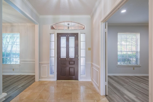 4226 Roaring Rapids Dr, Houston, TX 77059 - entryway featuring a decorative wall, healthy amount of natural light, light wood finished floors, crown molding, and wainscoting