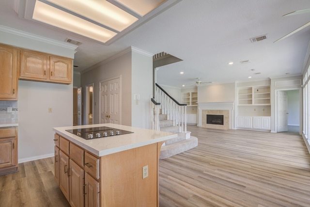 4226 Roaring Rapids Dr, Houston, TX 77059 - kitchen with ceiling fan, black electric cooktop, light wood-style floors, ornamental molding, and a fireplace