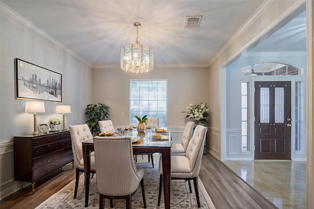 4226 Roaring Rapids Dr, Houston, TX 77059 - dining room featuring a chandelier, crown molding, a wainscoted wall, wood finished floors, and a decorative wall