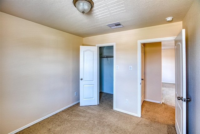 13230 Montane Manor Ln, Houston, TX 77044 - unfurnished bedroom with carpet floors, a closet, a walk in closet, and a textured ceiling