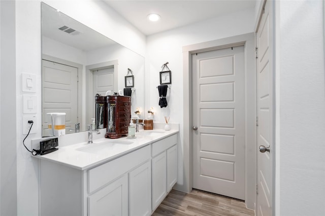 7730 Robert Ln, Rosharon, TX 77583 - bathroom featuring double vanity, wood finished floors, and recessed lighting