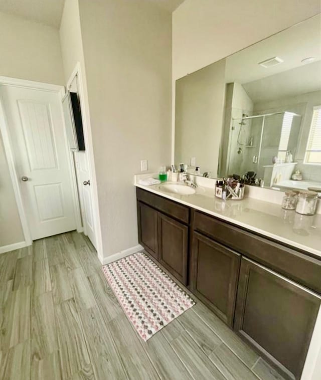 7638 Sirocco Ln, Baytown, TX 77523 - full bath featuring a shower stall, wood finished floors, double vanity, and baseboards