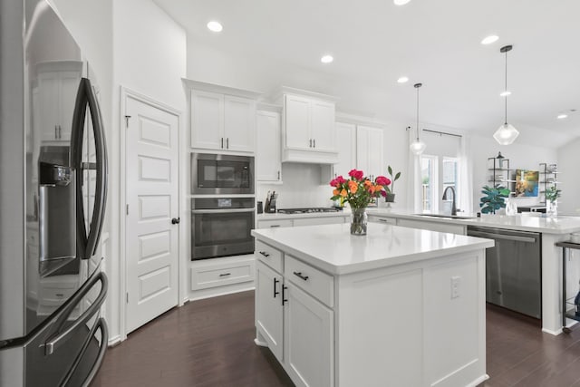 23014 Blackstone Park Rd, Katy, TX 77493 - kitchen featuring appliances with stainless steel finishes, a sink, a peninsula, dark wood-style floors, and light countertops