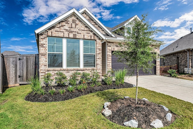 2410 Blazing Star Dr, Brookshire, TX 77423 - view of front of home with concrete driveway, brick siding, an attached garage, and a gate