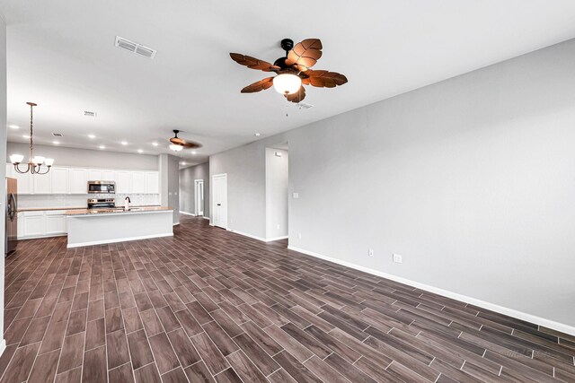2410 Blazing Star Dr, Brookshire, TX 77423 - unfurnished living room with ceiling fan, recessed lighting, baseboards, dark wood finished floors, and a sink