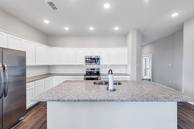 2410 Blazing Star Dr, Brookshire, TX 77423 - kitchen with stainless steel appliances, a sink, a center island with sink, decorative backsplash, and recessed lighting