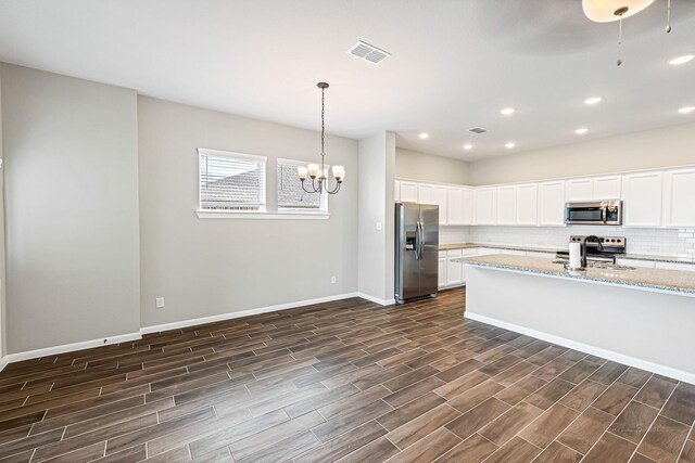 2410 Blazing Star Dr, Brookshire, TX 77423 - kitchen featuring stainless steel appliances, decorative backsplash, a sink, dark wood-type flooring, and a chandelier