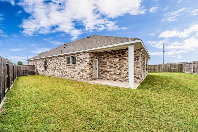 2410 Blazing Star Dr, Brookshire, TX 77423 - rear view of house with central AC, brick siding, a patio, and roof with shingles