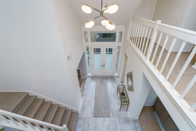 88 Sugarberry Cir, Houston, TX 77024 - entryway with high vaulted ceiling, stairs, a chandelier, wood finished floors, and baseboards