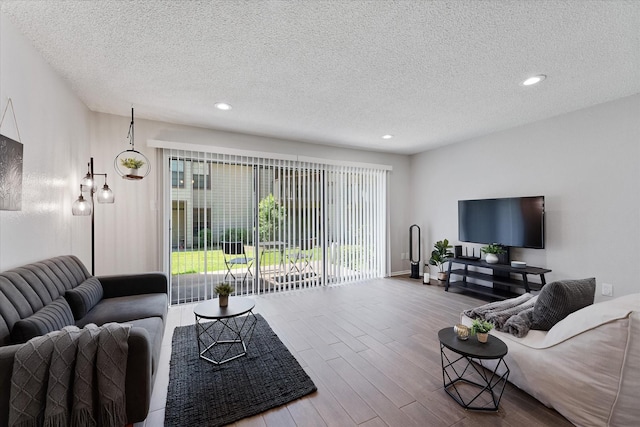 12900 Walden Rd Unit 415D, Montgomery, TX 77356 - living room featuring wood finished floors, a textured ceiling, recessed lighting, and baseboards