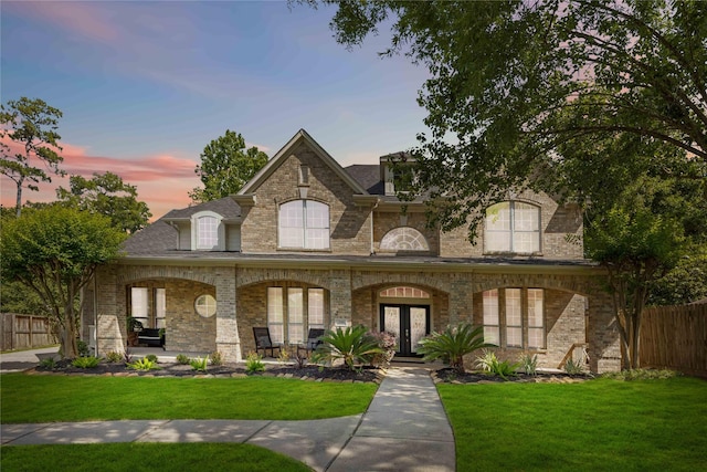 259 W Thorn Way, Houston, TX 77015 - french country home featuring a porch, brick siding, french doors, and a shingled roof