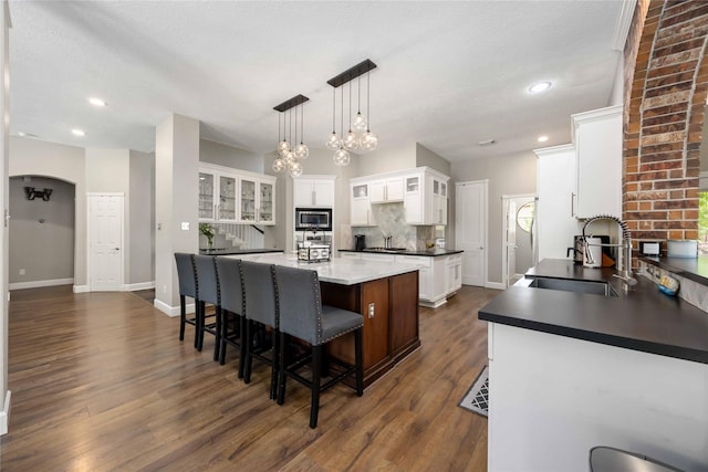 259 W Thorn Way, Houston, TX 77015 - kitchen with a sink, stainless steel microwave, white cabinetry, a kitchen island, and dark wood-style floors