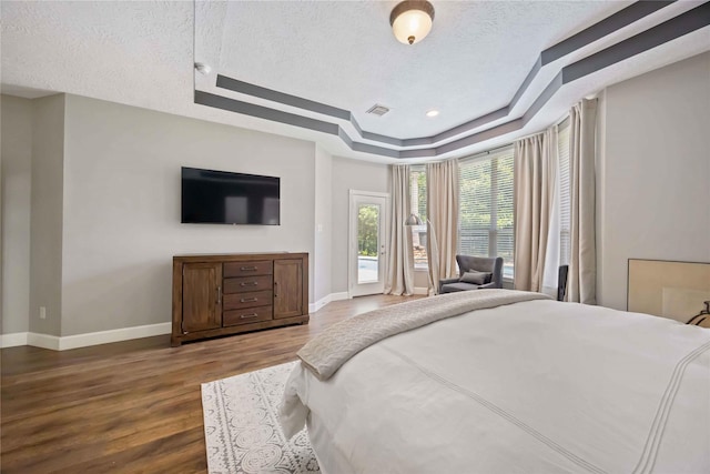 259 W Thorn Way, Houston, TX 77015 - bedroom featuring a tray ceiling, wood finished floors, baseboards, a textured ceiling, and access to outside
