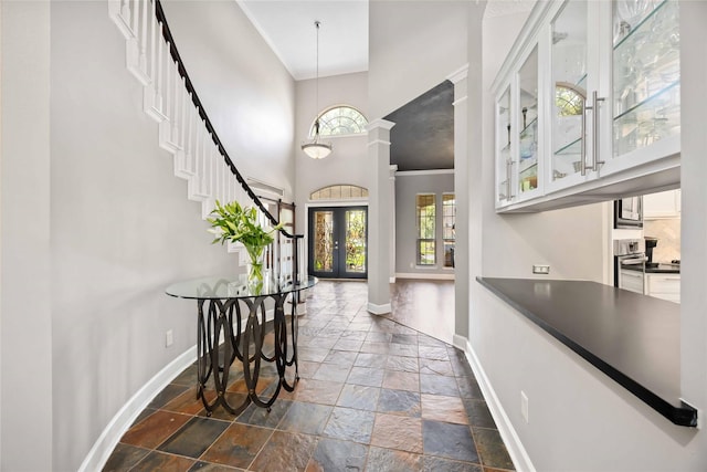 259 W Thorn Way, Houston, TX 77015 - foyer featuring baseboards, stone tile flooring, a towering ceiling, french doors, and ornate columns