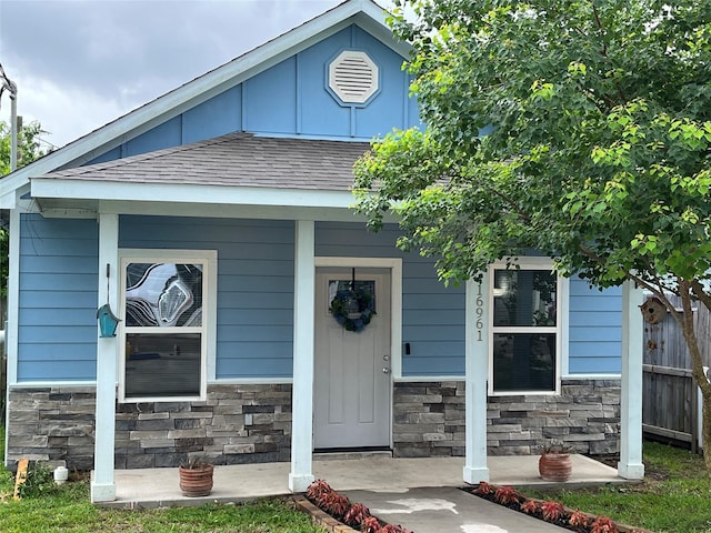 16961 W Hammon, Montgomery, TX 77316 - view of front facade with stone siding, a shingled roof, and covered porch