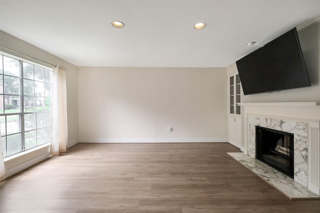 1321 Fountain View Dr Unit 131, Houston, TX 77057 - unfurnished living room featuring a fireplace, recessed lighting, wood finished floors, baseboards, and built in shelves