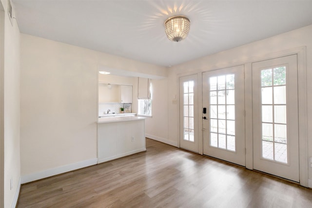 1321 Fountain View Dr Unit 131, Houston, TX 77057 - entryway featuring light wood-type flooring, french doors, baseboards, and a chandelier