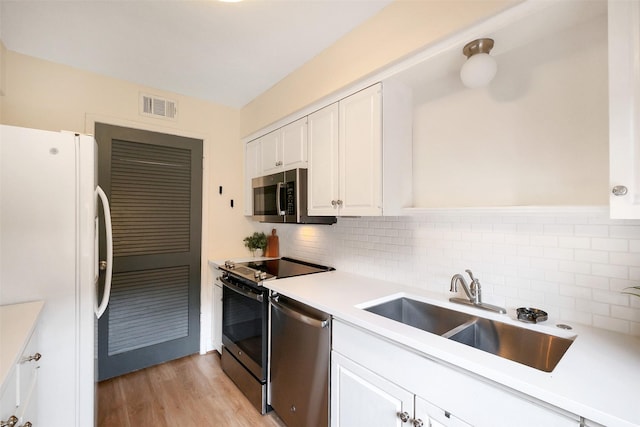 1321 Fountain View Dr Unit 131, Houston, TX 77057 - kitchen with appliances with stainless steel finishes, a sink, white cabinetry, and backsplash