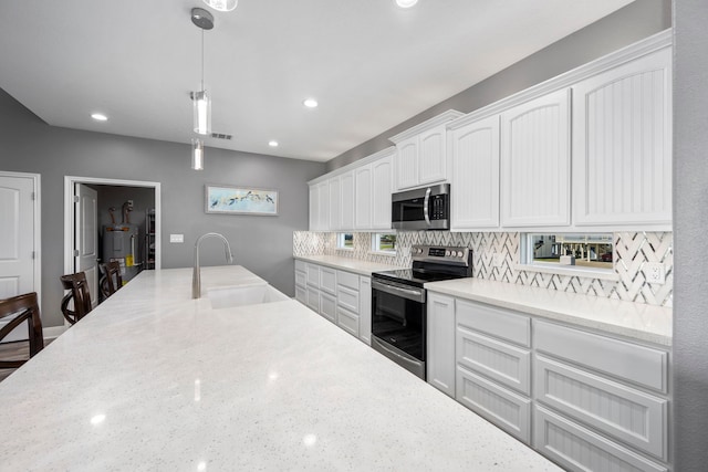 1816 Laguna Harbor Estate Blvd, Port Bolivar, TX 77650 - kitchen featuring stainless steel appliances, a sink, white cabinets, backsplash, and decorative light fixtures