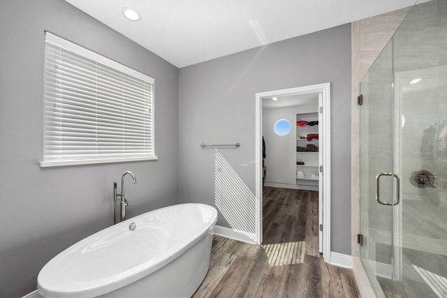 1816 Laguna Harbor Estate Blvd, Port Bolivar, TX 77650 - full bathroom featuring a stall shower, wood finished floors, a walk in closet, a soaking tub, and baseboards
