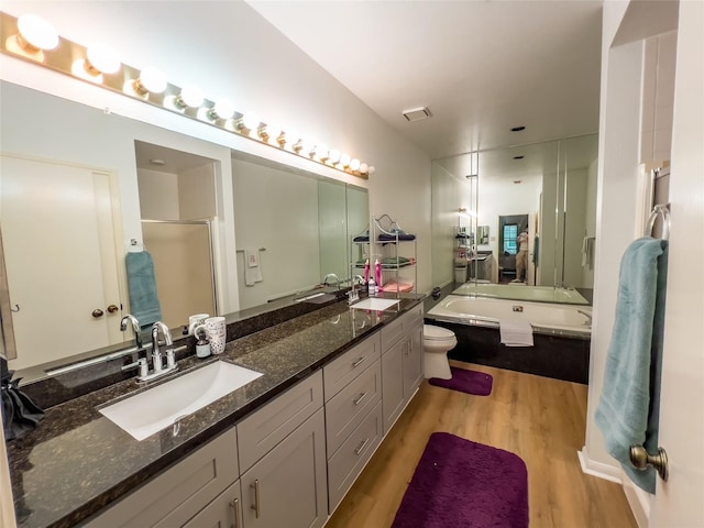 3212 Holly Hall St Unit 3212, Houston, TX 77054 - full bath with wood finished floors, double vanity, a bath, a shower with door, and toilet
