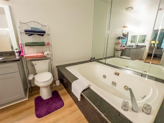 3212 Holly Hall St Unit 3212, Houston, TX 77054 - bathroom with a whirlpool tub, wood finished floors, vanity, and toilet