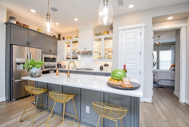 10914 Brambling Wood Dr S, Houston, TX 77043 - kitchen with stainless steel appliances, light stone counters, light wood-style floors, tasteful backsplash, and recessed lighting