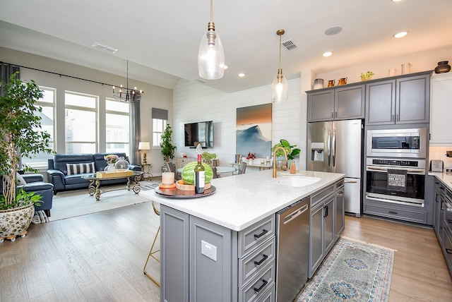 10914 Brambling Wood Dr S, Houston, TX 77043 - kitchen featuring stainless steel appliances, gray cabinets, a sink, open floor plan, and light countertops