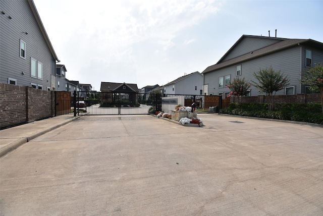 10914 Brambling Wood Dr S, Houston, TX 77043 - view of concrete road with a gate, a residential view, and curbs