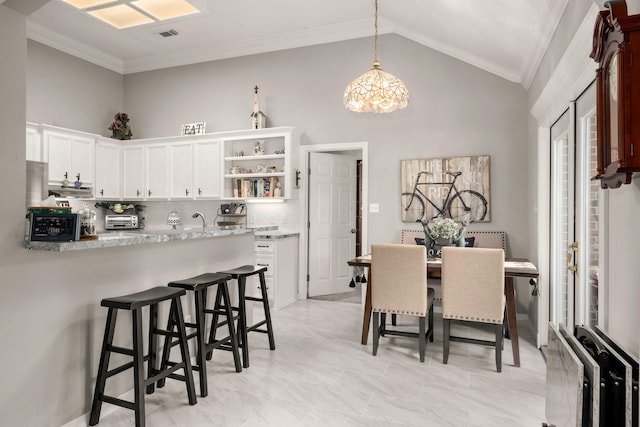 6927 Queensclub Dr, Houston, TX 77069 - dining area with ornamental molding, high vaulted ceiling, and a chandelier