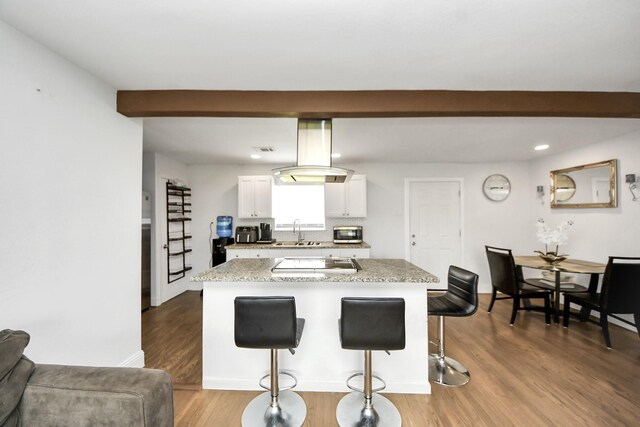 119 Burke Rd, Pasadena, TX 77506 - kitchen featuring a sink, a breakfast bar area, electric cooktop, white cabinets, and light countertops